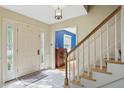 Bright foyer with white door, tile flooring, and staircase leading to the upper level at 1748 Sweet Gum Dr, Indianapolis, IN 46260