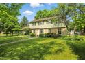 Traditional home with a spacious green lawn, complemented by lush trees and landscaping at 1748 Sweet Gum Dr, Indianapolis, IN 46260