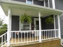 Cozy front porch with hanging ferns and seating at 203 W 3Rd St, Sheridan, IN 46069