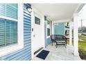 Charming front porch with seating area, freshly painted white trim and blue siding at 2209 W 9Th St, Muncie, IN 47302