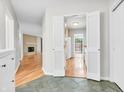 Hallway featuring white trim and an entry to kitchen and living area with fireplace at 2267 Rome Dr # A, Indianapolis, IN 46228