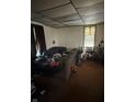 Living room with a brown carpet, ceiling tile and a window with curtains at 2310 Noble St, Anderson, IN 46016