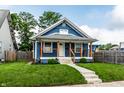 Charming blue home featuring a quaint front porch, well-maintained lawn, and welcoming curb appeal at 3764 Ruckle St, Indianapolis, IN 46205