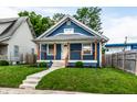 Charming blue home featuring a quaint front porch, well-maintained lawn, and welcoming curb appeal at 3764 Ruckle St, Indianapolis, IN 46205