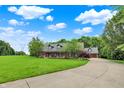 Expansive property featuring a brick home with a large front yard and a circular driveway leading to the garage at 4123 S Village Row, New Palestine, IN 46163