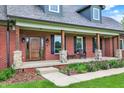 Close-up of the inviting front porch showcasing the wood columns and a beautifully crafted wooden door at 4123 S Village Row, New Palestine, IN 46163
