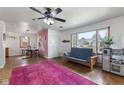 Bright living room featuring hardwood floors, large windows, and a vibrant pink rug at 4125 Bowman Ave, Indianapolis, IN 46227