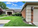 Charming brick home with a tan garage door, manicured lawn and detailed architectural features at 423 Bent Tree Ln, Indianapolis, IN 46260