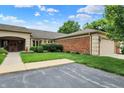 Brick home exterior with a tan garage door, well-maintained lawn, and manicured shrubs at 423 Bent Tree Ln, Indianapolis, IN 46260