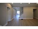Open-concept living room with freshly painted neutral-toned walls and modern light-colored laminate floors at 4231 Carrollton Ave, Indianapolis, IN 46205
