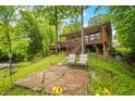 Lake house featuring a spacious deck, serene outdoor seating and steps to the home surrounded by lush greenery at 429 E Hoover Dr, Nineveh, IN 46164