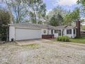 Front exterior featuring a charming one-story home with an attached garage, well-kept lawn, and brick details at 4305 Clinton St, Lawrence, IN 46226