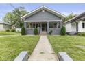 Charming single-story home featuring a manicured front yard with an inviting walkway and covered porch at 441 N Temple Ave, Indianapolis, IN 46201