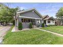 Charming single-story home featuring a manicured front yard with an inviting walkway and covered porch at 441 N Temple Ave, Indianapolis, IN 46201