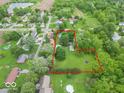 Expansive lot highlighted in red outline, surrounded by mature trees and greenery at 4526 Iowa St, Clayton, IN 46118