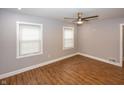 A gray bedroom featuring wood flooring, updated windows, and neutral decor at 4933 W 13Th W St, Speedway, IN 46224