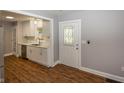 Bright kitchen featuring white cabinets, stainless steel appliances, and wood flooring at 4933 W 13Th W St, Speedway, IN 46224