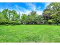 Expansive backyard with lush green lawn and mature trees, perfect for outdoor activities and relaxation at 4990 E County Road 750 S, Brownsburg, IN 46112