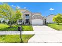 Beautiful two-story home boasts a manicured lawn, stylish brickwork, and an attached two-car garage at 515 Lynton Way, Westfield, IN 46074
