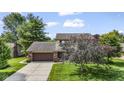 Two story home with brick and tan siding, long driveway, manicured lawn and mature landscaping at 5325 Ridge Hill Way, Avon, IN 46123