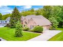 Beautiful brick home featuring a well-manicured lawn and an attached two car garage at 5404 Cayman Dr, Carmel, IN 46033