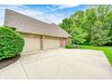 Spacious three-car garage with ample parking and a neatly landscaped yard at 5404 Cayman Dr, Carmel, IN 46033