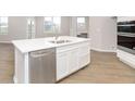 A kitchen island features a stainless steel dishwasher, white cabinets, and quartz countertop at 569 Dalton Way, Avon, IN 46123