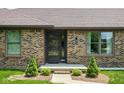 Inviting front entrance with a stylish door, brick accents, and manicured shrubs at 5905 N County Rd 600 E, Brownsburg, IN 46112