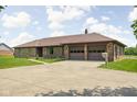 View of the brick home with a spacious two-car garage and concrete driveway at 5905 N County Rd 600 E, Brownsburg, IN 46112