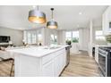 Open concept kitchen flowing into the living and dining areas, featuring a large island and modern finishes at 600 Dalton Way, Avon, IN 46123