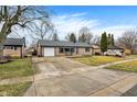 Well-kept home with a long driveway, attached garage, and established landscaping at 634 Park Dr, Greenwood, IN 46143
