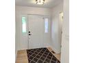 Bright entryway featuring light wood floors, a neutral color palette, a decorative rug, and a white front door at 6845 Arjay Dr, Indianapolis, IN 46217
