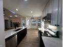 Bright kitchen boasts stainless steel appliances, white cabinetry, an island, and views to the living area at 6845 Arjay Dr, Indianapolis, IN 46217