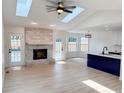 Open concept living area featuring a brick fireplace, skylights, recessed lighting, and patio access at 6845 Arjay Dr, Indianapolis, IN 46217