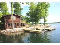 Lakeside cabin featuring a wooden deck and docks, offering direct access to the serene lake waters at 6937 Muskrat Dr, , IN 46164