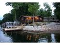 Waterfront cabin featuring docks, landscaping, and a wooden deck, perfect for lakeside relaxation and recreation at 6937 Muskrat Dr, , IN 46164