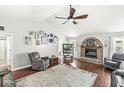 Comfortable living room features wood floors, a brick fireplace, and a vaulted ceiling at 7221 State Road 42, Martinsville, IN 46151