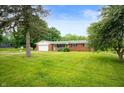 Quaint single story brick home with an attached garage, mature trees and lush green lawn at 8027 S 250 E, Markleville, IN 46056