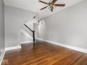 Spacious living room featuring beautiful hardwood floors, a ceiling fan, and staircase at 914 English Ave, Indianapolis, IN 46203