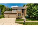 Charming brick two-story home featuring a manicured lawn, mature trees and an attached two-car garage at 9804 Wentworth Ct, Carmel, IN 46032