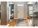 Bright foyer featuring hardwood floors, neutral paint, an elegant entry door, and access to the living area at 9804 Wentworth Ct, Carmel, IN 46032