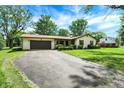 Traditional one-story home with attached garage, green lawn, and asphalt driveway at 101 Heiny Rd, Indianapolis, IN 46217