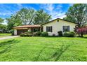Ranch-style home with green lawn, covered porch, and attached garage at 101 Heiny Rd, Indianapolis, IN 46217