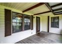 Cozy covered porch featuring wood decking, decorative shutters, and a glass front door at 101 Heiny Rd, Indianapolis, IN 46217