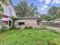 Front exterior shot of a home with a small overgrown yard, faded paint, and visible wear at 1140 Mcdougal St, Indianapolis, IN 46203