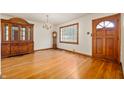 Bright living room with hardwood floors, elegant chandelier, and classic wood door at 1212 Woodlawn Ave, Indianapolis, IN 46203