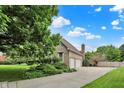Exterior view of home showing attached garage, lush landscaping and private driveway at 1410 Shadow Ct, Zionsville, IN 46077
