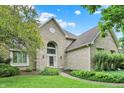 Charming brick home featuring arched entryway, manicured lawn and mature trees at 1410 Shadow Ct, Zionsville, IN 46077