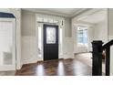 Welcoming entryway with dark wood floors, wainscoting, and a decorative front door at 15023 Glenmoor Cir, Carmel, IN 46033