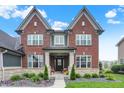 Charming two-story brick home with stone accents and manicured landscaping at 15023 Glenmoor Cir, Carmel, IN 46033